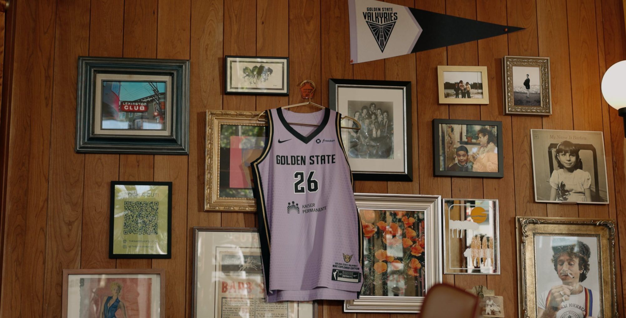 Violet Valkyries jersey hanging on a wall of framed photos